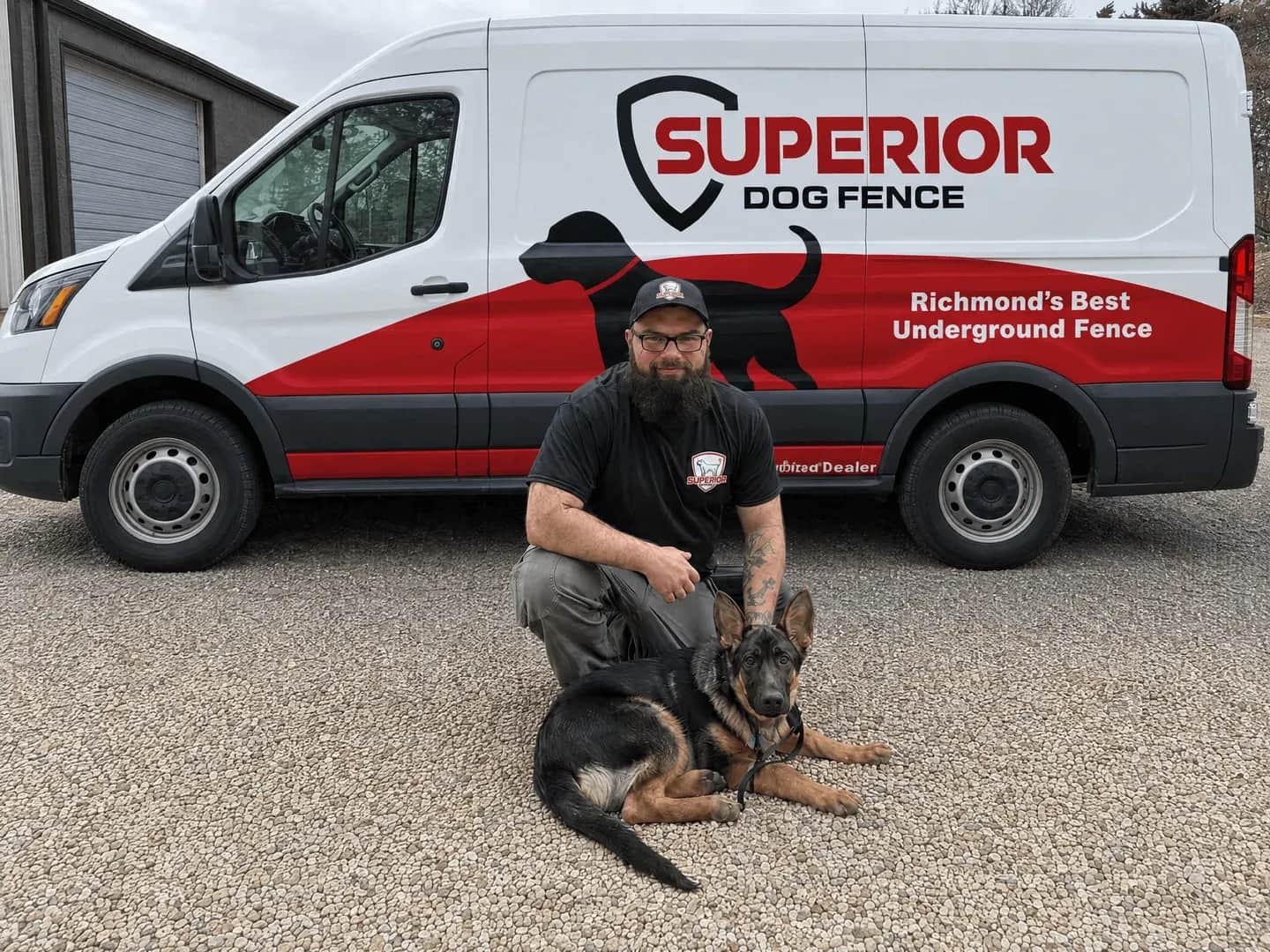 An installer kneeling with a German shepherd in front of the Superior van.